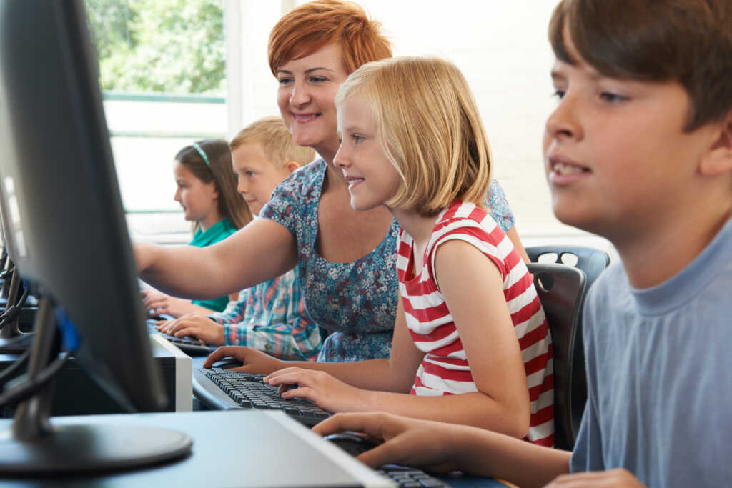 Teacher working with students on computer