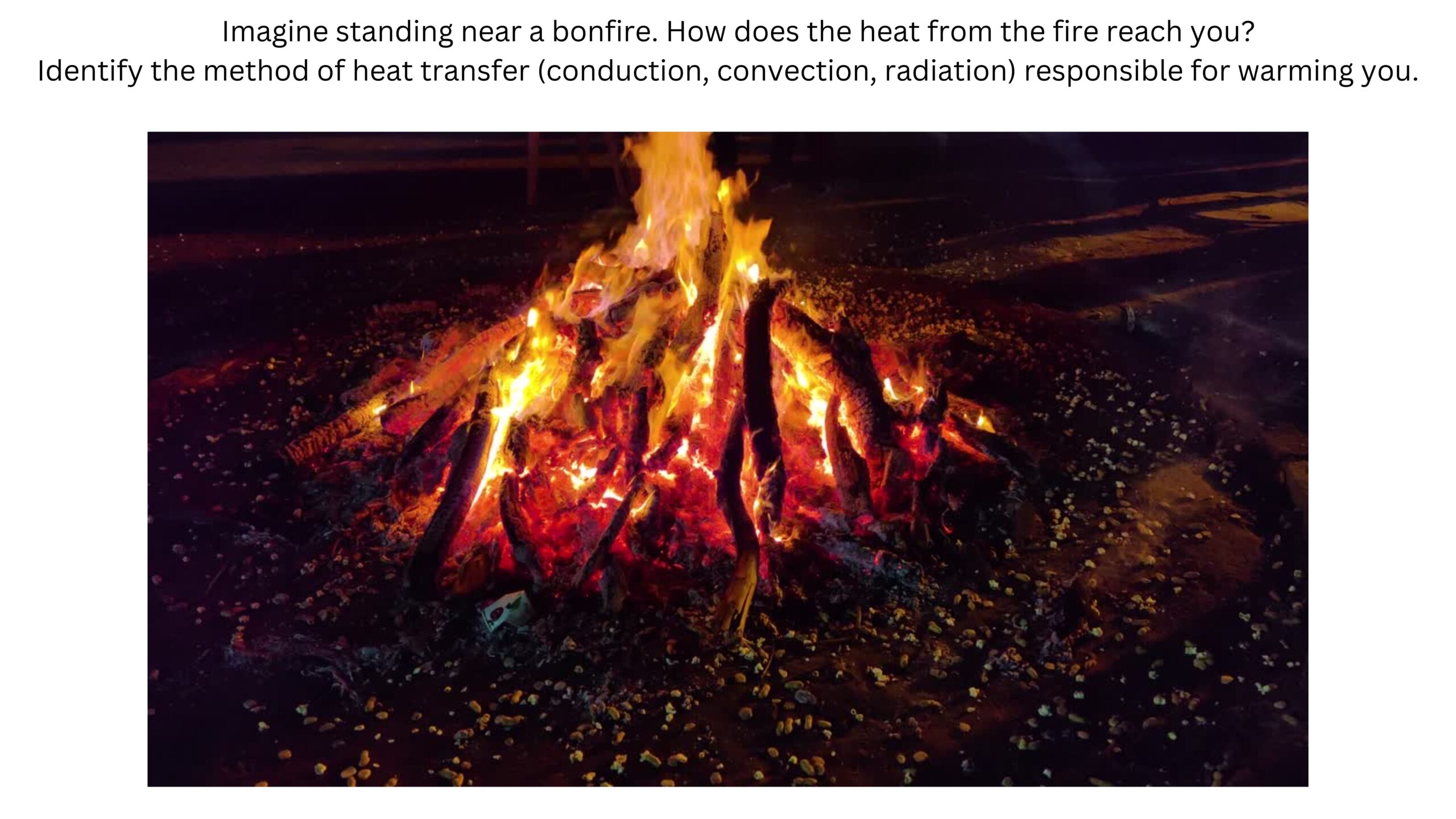 Imagine standing near a bonfire. How does heat from the fire reach you? Identify whether conduction, convection, or radiation is responsible for warming you. A large outdoor bonfire burns brightly at night.